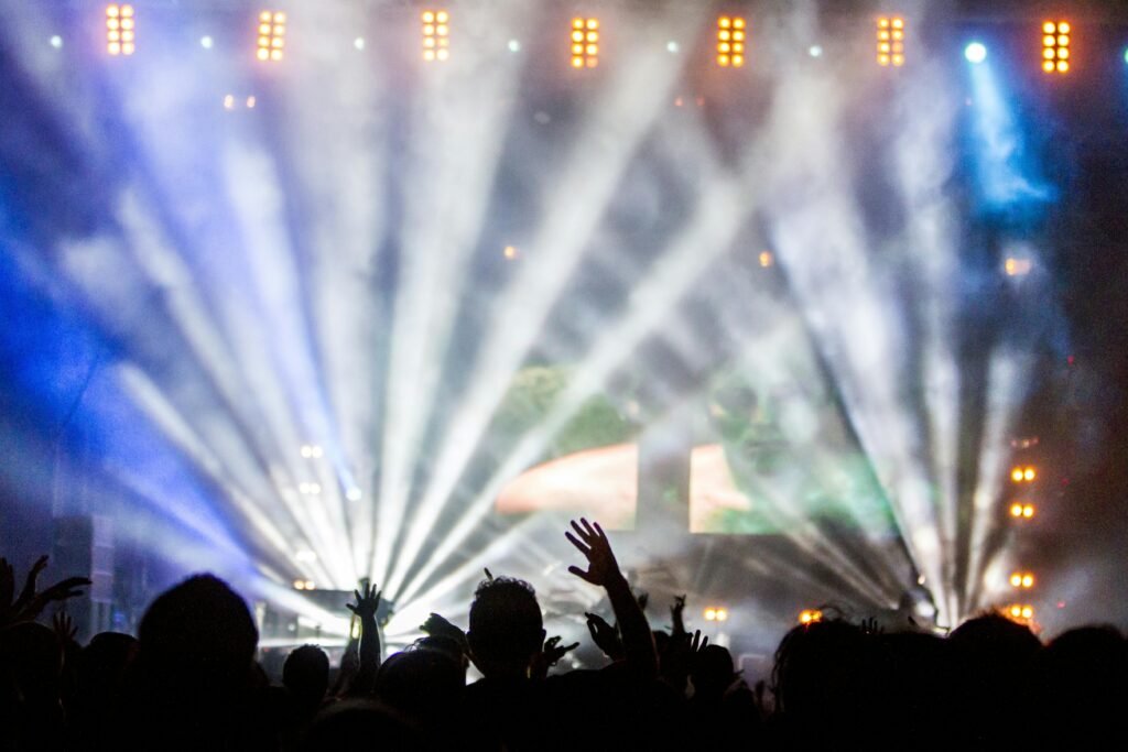 Vibrant nightclub concert with cheering crowd and dazzling spotlights.